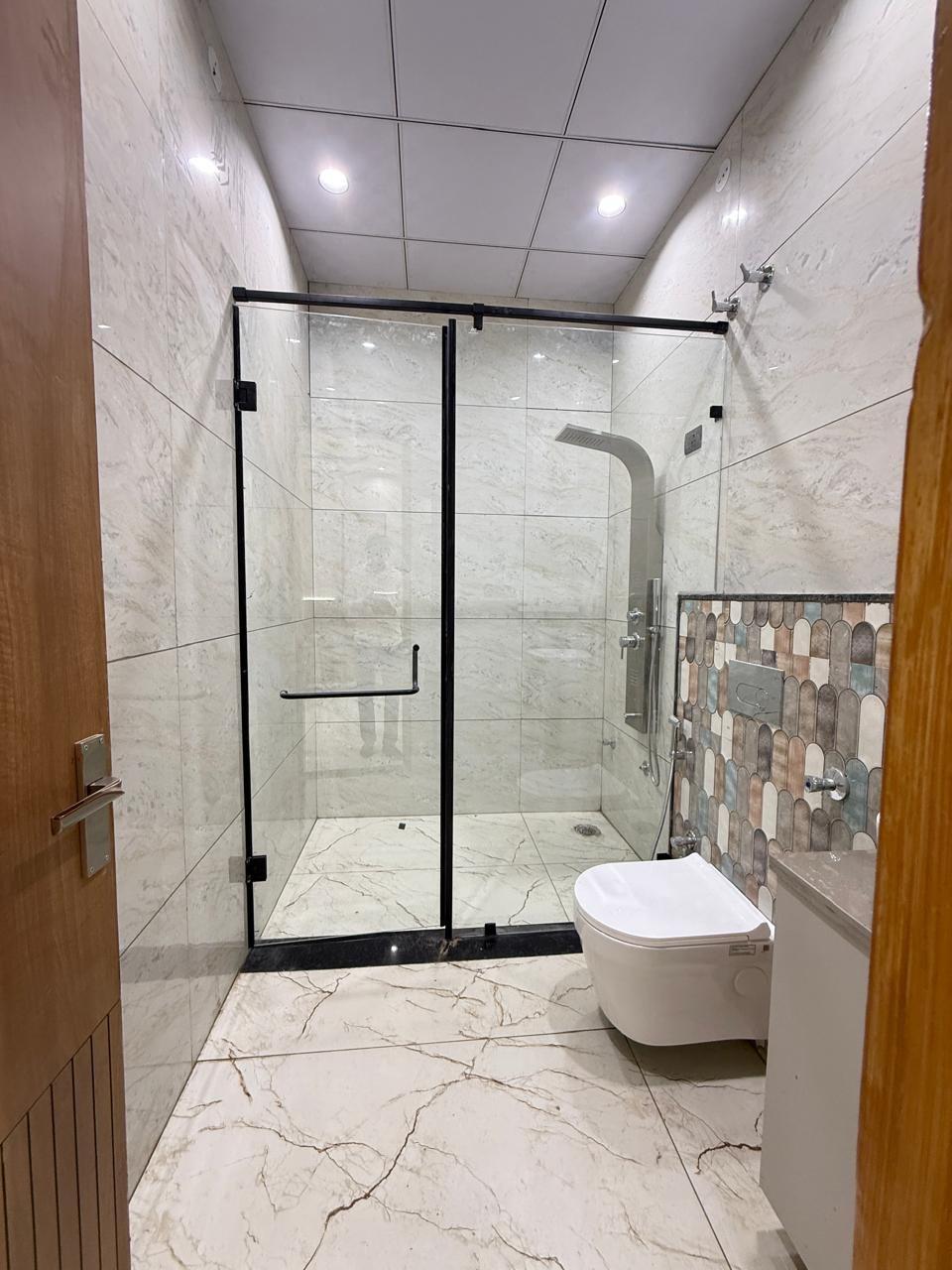 Bathroom with glass shower and marble walls