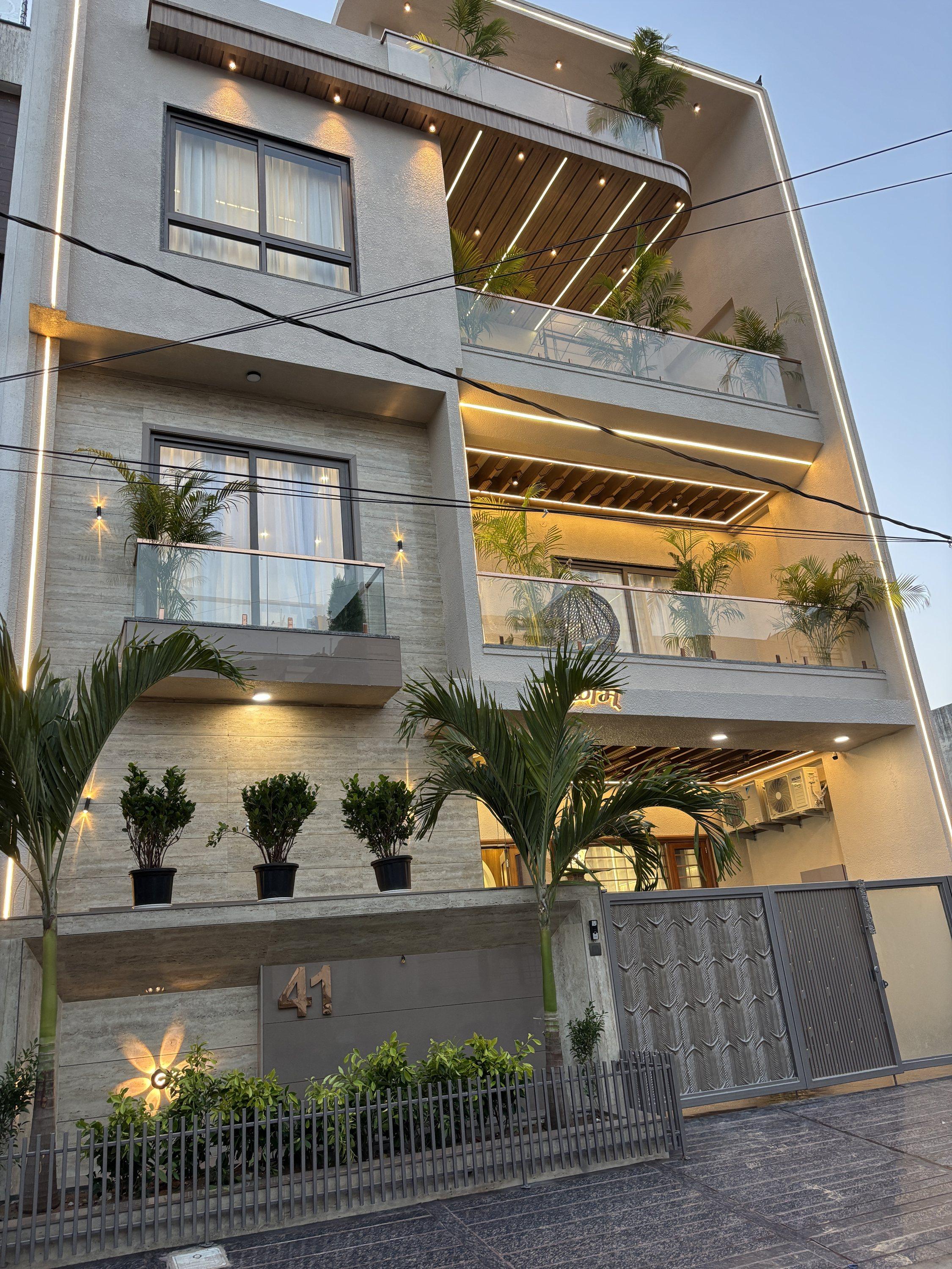 Three-storey facade with planters and warm lighting